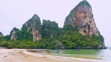 Turkuaz suyu olan Railay kumlu plajı, Tayland 'ın Krabi eyaletindeki geleneksel Tayland tekneleri ve uçurumları. Asya 'da popüler turistik tatil beldesi.