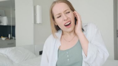 Güçlü kulak ağrısından muzdarip genç bir kadın. Kulak iltihabı ve kulak iltihabı olan üzgün bir kadın. Sağlık sorunları kavramı. 