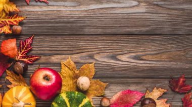 Şükran Günü, Cadılar Bayramı ve sonbahar geçmişi. Balkabakları, elmalar, yapraklar, kuru çiçekler ve taşralı ahşap masada fındıklar ile sonbahar kompozisyonu. Düz yatış, üst görünüm.