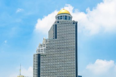 Bangkok City, Tayland 'da altın kubbeli ve parlak mavi gökyüzünün altında balkon desenleri olan yüksek binalar..