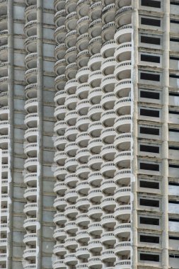 Tayland 'ın Bangkok şehrinde, mimari tasarım sergilenen, raylı, kıvrımlı balkon desenleri ile tamamlanmamış yüksek binalar cephesi. Soyut mimari arka plan. Dikey