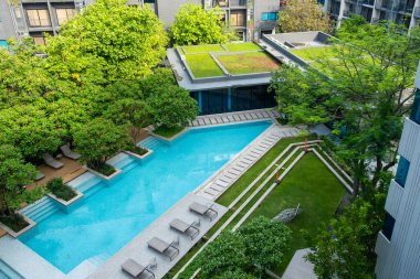 Geniş bir açık yüzme havuzu, yemyeşil bahçeleri ve Tayland 'ın Bangkok şehrinde huzurlu bir şehir vahası sunan modern apartman kompleksi..