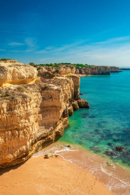 Albufeira yakınlarındaki kayalıklı kumsal, Algarve bölgesi, Portekiz, Avrupa. Portekiz Atlantik kıyı şeridinde yaz tatili için popüler turistik bir yer. Dikey yönelim.