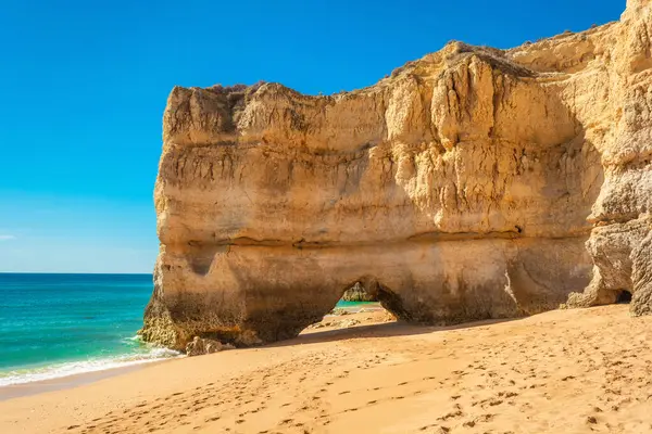 Güneşli bir günde Portekiz 'in Algarve bölgesinde Portimao yakınlarında kemerli dev kayalıklı kumsal. Portekiz Atlantik kıyısında yaz tatili için popüler turizm beldesi.