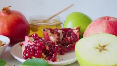 Beyaz zemin üzerinde bal, nar ve elma bulunan Yahudi bayramı Rosh Hashana yemekleri.