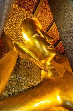 Golden Big Buddha statue in Wat Pho Temple in Bangkok city, Thailand, Asia. Temple of the Reclining Buddha. Vertical orientation. Popular tourist landmark. clipart