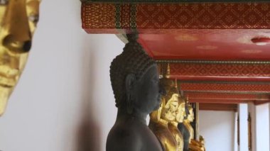 Bangkok, Tayland, Asya 'daki Wat Pho Tapınağı Kompleksi' nde altın Buda heykelleri sıralanmıştır. Yaslanmış Buda 'nın Tapınağı. Popüler seyahat simgesi.