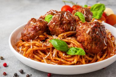 Domates soslu makarna soslu makarna, üzerinde parmesan peyniri ve taze fesleğen yaprağı. Lezzetli İtalyan yemekleri. Kapat..