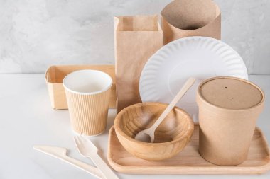 Eco-friendly, biodegradable disposable tableware and cutlery made of paper and wood. Cups, bags, cutlery and food containers for sustainable and environmentally conscious food service. Mock up. clipart