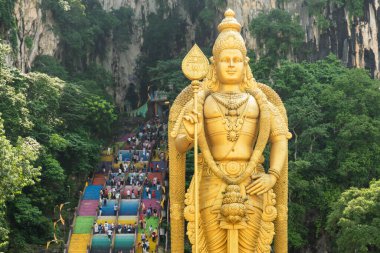 Batu Mağaraları Hindu Tapınağı, Selangor, Malezya. Lord Murugan 'ın altın heykeli renkli merdivenlerde gezen turistler Batu mağara kompleksi Kuala Lumpur' a çıkıyor. Asya 'da seyahat Hinduizm simgesi.