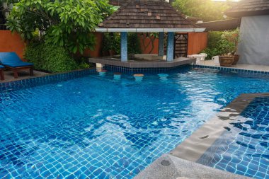 Açık mavi suyu olan tropik bir tatil köyü yüzme havuzu ve Tayland 'ın Phi Phi adasında küçük bir pavyonun gölgelediği oturma alanı olan bir yüzme barı. Lüks seyahat ve turizm.