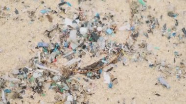 Deniz kıyısı kirliliği. Tayland, Phuket Adası 'ndaki kumlu sahilde mikro plastik parçacıkları ve enkazı kapatın. Kumda çöp ve çöp. Çevre sorunları ve deniz kirliliği.