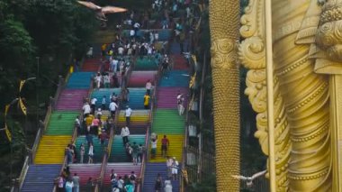 Kuala Lumpur, Malezya - 7 Haziran 2024: Batu Caves Hindu Tapınağı, Selangor, Malezya. Lord Murugan 'ın altın heykeli renkli merdivenlerde gezen turistler Batu mağara kompleksi Kuala Lumpur' a çıkıyor. Seyahat