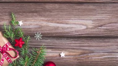 Köknar dalları, hediye kutuları, kırmızı süslemeler ve köy ahşap masasında çam kozalakları olan Noel arkaplanı. Düz yatıyordu. Mutlu yıllar ve kış tatilleri. Üst görünüm.
