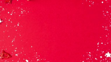 Noel çerçevesi köknar dallarından, hediye kutularından, şenlikli dekorasyonlardan, kırmızı arka planda şeker ve çam kozalaklarından yapıldı. Düz yatıyordu. Mutlu yıllar ve kış tatili konsepti. Kopyalama alanı olan üst görünüm.