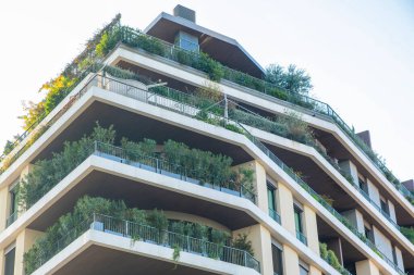 Teraslarda verimli yeşillikleri olan modern apartman binası, çevre dostu kentsel yaşam ve mimari yenilikler sergileniyor, Milan, İtalya. Çevre dostu şehir ortamı. Sürdürülebilir modern ve