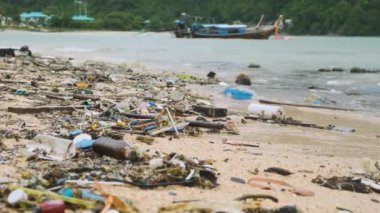 Tayland 'ın Phuket adasındaki deniz kıyısında plastik atık ve molozlarla kirlenmiş plaj. Deniz kıyısındaki kumda çöp ve çöp. Çevre sorunları ve deniz kirliliği.