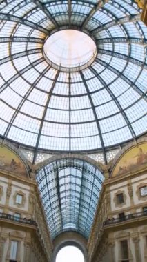 Galleria Vittorio Emanuele II 'nin içi, İtalya, Milan' da. Büyük cam kubbesi ve Milano şehrindeki dekoratif detayları olan en eski İtalyan alışveriş merkezi neoklasik mimarisi. Dikey yönelim