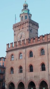 Piazza Maggiore, Emilia Romagna, İtalya 'da Palazzo dAccursio' lu Bologna eski kasabası. Gündoğumunda şehir meydanındaki kulede büyük saati olan belediye binasında kimse yoktu. Dikey oryantasyon. Seyahat