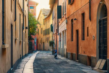 Ortaçağ dar sokaklarında güneş doğarken Bologna 'nın eski kasabası Emilia Romagna' da kimse yok. Renkli bina cepheli İtalyan caddesi. Avrupa 'da seyahat hedefi.