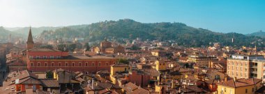 Bologna 'nın eski kenti Emilia Romagna' nın hava panoramik manzarası, kırmızı kiremit çatıları, kilise kulesi, ortaçağ mimarisi ve gündoğumunda yeşil tepeler. İtalyan şehir manzarası. Seyahat