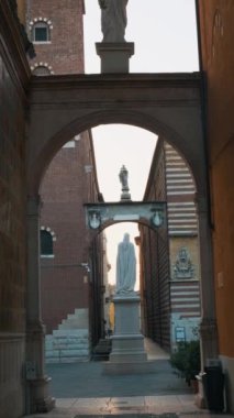Dante Alighieri heykeli İtalya 'nın Veneto kentindeki Verona' daki Piazza Signori 'de. Dar tarihi caddelerde, tuğladan binalar ve mimari detaylarla dolu kemerli bir geçit. Dikey