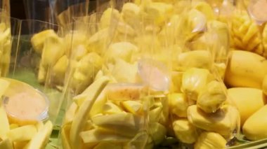 Bangkok, Tayland yakınlarındaki Damnoen Saduak Yüzen Pazarı 'nda satmak için bir teknede taze ve dilimlenmiş mango meyvelerini kapatın. Asya 'da seyahat ve turistik dönüm noktası.