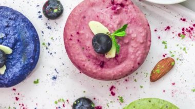 Sağlıklı vejetaryen peynirli kekler. Kibrit, acai, yabanmersini, nane ve fındıklı renkli çiğ kaju kekleri. Glütensiz diyet yemeği. Üst Manzara. düz yat