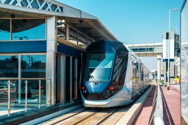 Dubai tramvayı modern istasyona geliyor. Birleşik Arap Emirlikleri, Dubai şehrinde sokak ve gelecekteki ulaşım altyapısı trafiği. Kentsel çevre.