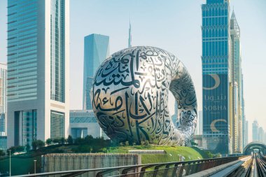 Dubai, BAE - 5 Mayıs 2024: Dubai POV görüntüsü modern gökdelenler ve Gelecek Müzesi 'nden geçen metro treninden Şeyh Zayed Yolu' nun yanında. Dubai şehrinin gelecekteki mimarisi, Birleşik