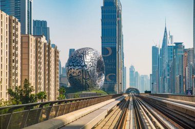Dubai, BAE - 5 Mayıs 2024: Modern metro yolu, gökdelenler ve Geleceğin Müzesi ile fütürist gökyüzü. Dubai şehrinin gelecekteki mimarisi, Birleşik Arap Emirlikleri.