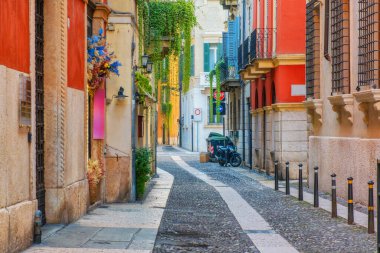 Gündoğumunda İtalya 'nın Veneto kentindeki Verona eski kasabasında renkli bina cepheleri ve kaldırım taşları olan ortaçağ dar sokakları. İtalyan caddesinde kimse yok. Avrupa 'da seyahat hedefi.