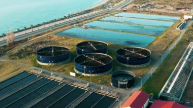 Sahil bölgesi yakınlarında dairesel tankları ve tortu havuzları olan modern atık su arıtma tesisinin havadan görünüşü. Sürdürülebilir su yönetimi. Çevre Yönetimi.