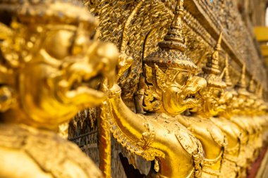 Bangkok, Tayland 'daki en kutsal Budist tapınağı olan Zümrüt Buda Tapınağı Wat Phra Kaew' in dış duvarlarını süsleyen Altın Garuda heykelleri. Detaylı Tayland mitolojisi