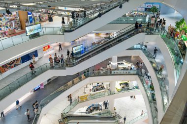 Bangkok, Tayland - 2 Şubat 2025: Birden fazla yürüyen merdiven ve farklı seviyelerde hareket eden insanlarla birlikte alışveriş merkezinin içini düşünüyorum. Geometrik, perspektifli, fütürist modern alışveriş merkezi