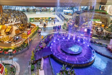 Bangkok, Tayland - 2 Şubat 2025: Canlı ışıklandırma, merkez su fıskiyesi ve dekoratif bitkilerle çevrili restoran bölgesi ile alışveriş merkezinin içini düşünüyorum. Modern alışveriş merkezi