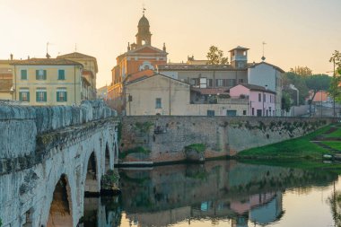 Marecchia nehrinin üzerinde Tiberius Köprüsü olan Rimini kasabası, gün doğumunda, Emilia-Romagna, İtalya. Ortaçağ mimarisi ve Ponte di Tiberio ile İtalyan şehri. Turizm ve seyahat beldesi.
