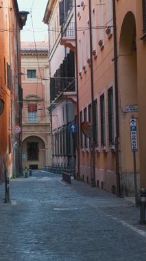 Ortaçağ dar sokaklarında güneş doğarken Bologna 'nın eski kasabası Emilia Romagna' da kimse yok. Renkli bina cepheli İtalyan caddesi. Dikey oryantasyon. Avrupa 'da seyahat hedefi.