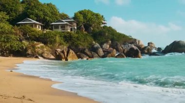 Altın kumu, turkuaz dalgalı suyu, yemyeşil kayalık kıyı şeridi ve berrak mavi gökyüzü altında deniz kenarındaki villaları olan tropik bir sahil. Tayland 'daki Koh Samui adasındaki Mercan Koyu kumlu plajı. Yaz