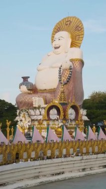 Tayland 'daki Koh Samui adasındaki Wat Plai Laem tapınağında zengin dekore edilmiş Buda heykeli. Dikey oryantasyon. Seyahat ve turistik dönüm noktası.