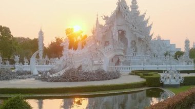 Beyaz tapınak Wat Rong Khun 'un etrafı güneş ışığıyla çevrili, Chiang Rai, Tayland. Kuzey Tayland 'daki Budist tapınağı. Asya 'da seyahat ve turistik dönüm noktası.