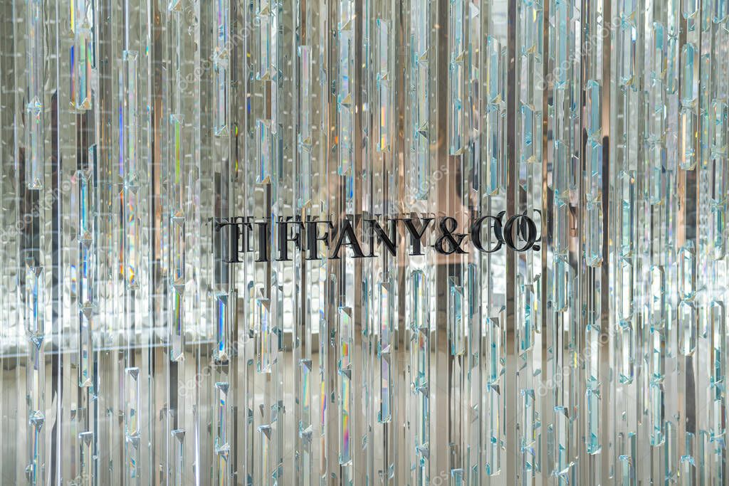 Bangkok, Thailand - March 19, 2025: Tiffany Co. logo behind shimmering vertical crystal rods in luxury jewelry store window display in shopping mall in Bangkok city.