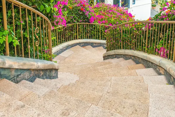 Titrek pembe bougainvillea ve verimli yeşilliklerle çevrili kavisli merdiven Sunset Town, Phu Quoc Adası, Vietnam. Asya 'da İtalyan mimarisi. Romantik bahçe tasarımı