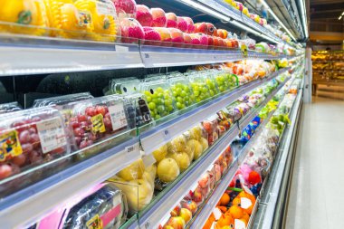 İçinde üzüm, elma, mango, armut, vitrin tazeliği, rahatlık ve sağlıklı beslenme gibi paketlenmiş taze meyvelerin bulunduğu süpermarket meyveli bölüm. Markette gıda perakendecisi