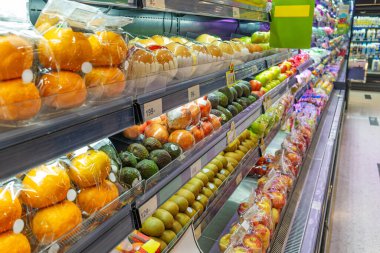 Süpermarket meyve soğutma bölümünde portakallar, elmalar, avokado ve kivi, vitrin tazeliği, kolaylık ve sağlıklı yiyecekler de dahil olmak üzere paketlenmiş taze meyveler var. Markette gıda perakendecisi