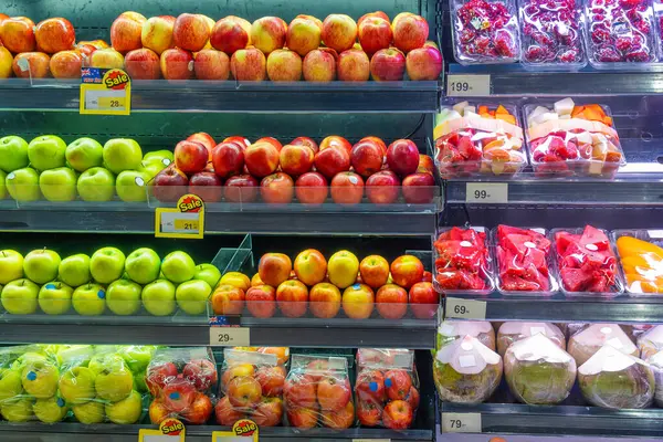 Süpermarkette satılığa çıkarılmış taze, besleyici ve sağlıklı seçenekleri destekleyen paketlenmiş tropikal meyveler ve renkli elmalar. Tayland 'daki bakkalda gıda perakendecisi.