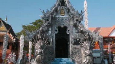 Tayland, Chiang Mai 'de açık mavi gökyüzü altında karmaşık ejderha oymaları ve detaylı metal işleriyle Gümüş Tapınak' a giriş. Wat Sri Suphan Budist Tapınağı. Asya mimarisi. Seyahat ve turistik