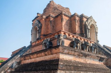 Chiang Mai, Tayland 'da açık mavi gökyüzünün altında dik merdivenleri ve fil heykelleri olan Wat Chedi Luang' ın antik tuğla stupası. Budist tapınağı. Tayland dini mimarisi. Seyahat ve turistik