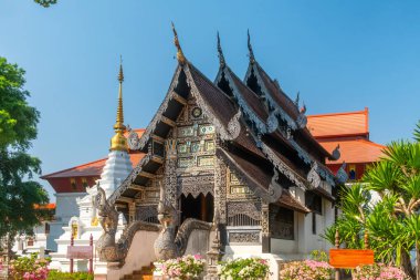Tayland, Chiang Mai 'de açık mavi gökyüzü altında karmaşık oymalar ve naga heykelleriyle süslü ahşap Tayland tapınağı. Budist tapınağı. Tayland dini mimarisi. Seyahat ve turistik dönüm noktası.