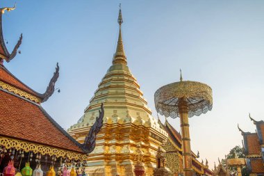 Altın stupa Budist tapınağı Wat Phra Doi Suthep 'de gün batımında Chiang Mai, Tayland' da altın bir tören şemsiyesi ile. Tayland dini mimarisi. Seyahat ve turistik dönüm noktası.